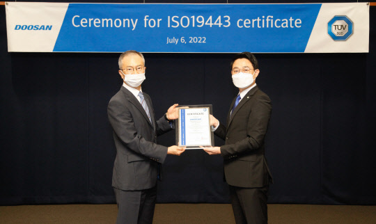 지난 6일 분당두산타워에서 열린 ISO 19443 인증서 수여식에서 강홍규(왼쪽) 두산에너빌리티 원자력BG 상무와 서정욱 TUV SUD Korea 대표이사가 기념촬영을 하고 있다. <두산에너빌리티 제공>